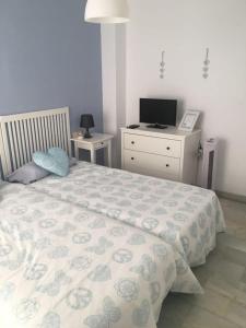 1 dormitorio con 1 cama y vestidor con TV en Moderno apartamento con piscina disponible según restricciones sequía, en Torremolinos