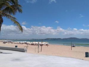 una playa con un montón de sombrillas y el océano en Casa em Cabofrio, en Cabo Frío