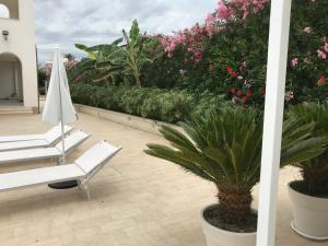 a patio with a white chair and a plant at Archiammare Sea in San Lorenzo