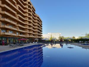 a swimming pool in front of a large building at Dom Pedro Portobelo in Vilamoura
