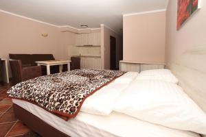 a bedroom with a bed with a leopard blanket on it at Apartamenty Rok in Kołobrzeg