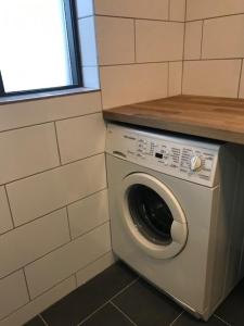 a washer and dryer in a corner of a room at Fell Holiday Home in Arnarstapi