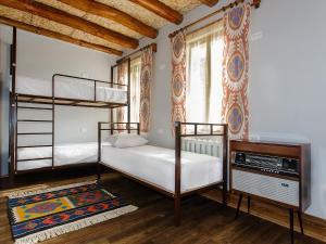 a bedroom with two bunk beds and a television at Dervish Hostel in Bukhara