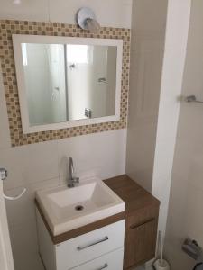 a bathroom with a sink and a mirror at Apto Central para Família in Balneário Camboriú