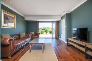 a living room with a leather couch and a tv at Watley Farm in Winchester