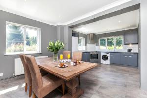 a kitchen and dining room with a wooden table and chairs at Watley Farm in Winchester