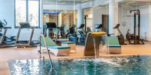 a gym with a swimming pool and exercise equipment at DOR Apartment in Poiana Brasov