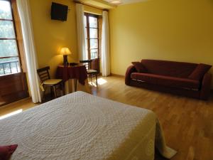 sala de estar con cama y sofá en Hotel Restaurante Casa Petronila, en Taramundi