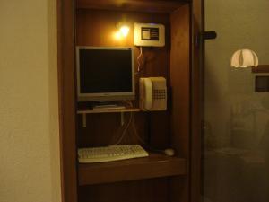 a computer on a shelf with a phone and a keyboard at Regerhof in Germering