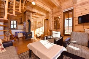 a living room with furniture and a fireplace in a log cabin at Mekų sodyba in Degučiai