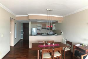 Un comedor y una cocina con mesa y sillas. en Jardines de Belgrano, en Salta