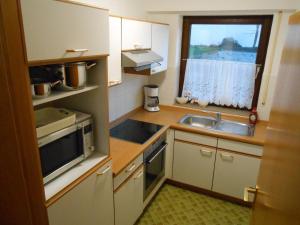 eine kleine Küche mit Spüle und Fenster in der Unterkunft Homeaway in Winterberg