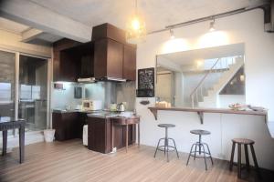 a kitchen with a counter and two bar stools at Liu House in Jiufen