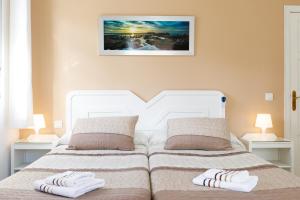 a bedroom with two beds with towels on them at AT Almoraide Rooms Suites in Nerja