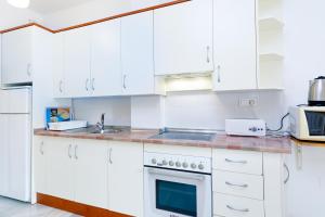 a white kitchen with white cabinets and a sink at AT Almoraide Rooms Suites in Nerja