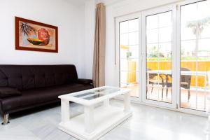 a living room with a couch and a coffee table at AT Almoraide Rooms Suites in Nerja