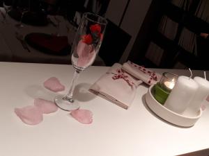 un tavolo con un bicchiere di vino e una candela e cuori di Wall Art Hotel & Residence a Prato