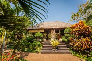 a house with a wooden walkway in front of it at Zen Resort Bali in Umeanyar