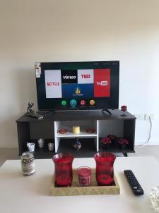 a tv sitting on top of a table with red glasses at Amplio, moderno y luminoso departamento en la mejor zona de Tigre in Tigre