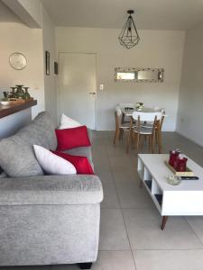 ein Wohnzimmer mit einem Sofa und einem Tisch in der Unterkunft Amplio, moderno y luminoso departamento en la mejor zona de Tigre in Tigre