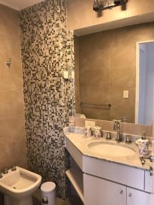 a bathroom with a sink and a toilet and a mirror at Amplio, moderno y luminoso departamento en la mejor zona de Tigre in Tigre