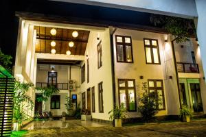 un gran edificio blanco con ventanas y plantas en Hotel Bella Vista, en Anuradhapura