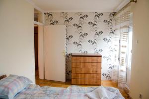 Un dormitorio con una cama y una cómoda. en Apartman White, en Belgrado