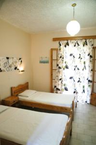a room with two beds and a window at Marios Studios in Sidari