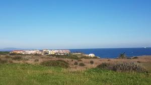 a group of houses on a hill next to the ocean at Alma House in Porto Torres