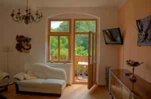 ein Wohnzimmer mit einem weißen Stuhl und einem Fenster in der Unterkunft Domizil Adler in Dresden