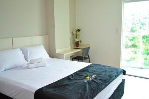 a bedroom with a bed and a desk and a window at Evidence Hotel in Sapucaia