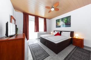 Hotel Avalon في لنداشتول: غرفة نوم بسرير وتلفزيون بشاشة مسطحة