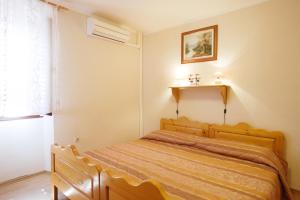 ein Schlafzimmer mit einem Holzbett in einem Zimmer in der Unterkunft Rooms Sara in Grožnjan