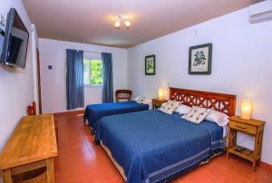 a bedroom with two beds and a flat screen tv at El Cortijo in Pinamar
