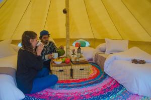ArcabucoGlamping Finca Corazón的坐在帐篷里的男人和女人