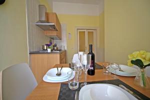 una cucina con tavolo, bicchieri e una bottiglia di vino di Seawall Holiday Home a Salerno