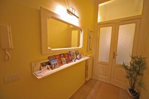 baño con espejo, estante y puerta en Seawall Holiday Home, en Salerno