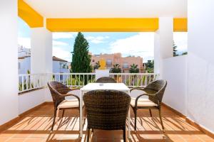 a patio with a white table and chairs on a balcony at AT Almoraide Rooms Suites in Nerja