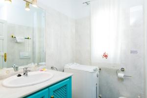 a white bathroom with a sink and a mirror at AT Almoraide Rooms Suites in Nerja