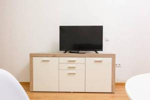 a flat screen tv sitting on top of a white cabinet at Canadian 1 in Córdoba