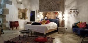 a bedroom with a bed and a blue couch at Bocage Belle Histoire in Moutiers-sous-Chantemerle