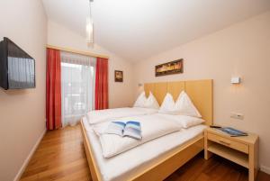 a bedroom with a bed with two blue books on it at Arabella Golf- und Ski-Appartement in Zell am See