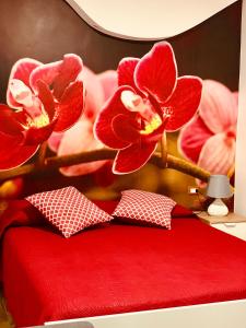 een slaapkamer met een rood bed met rode bloemen erop bij B&B Di Fiore in Peschici