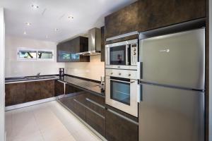 a kitchen with stainless steel appliances and brown cabinets at Victory Village 3A in Quinta do Lago