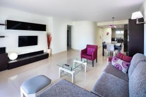 a living room with a couch and chairs and a tv at Victory Village 3A in Quinta do Lago