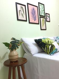 Zimmer mit einem Bett und einem Tisch mit einer Vase in der Unterkunft Pousada Rio Alegre in Santo Amaro