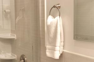 y baño con ducha y toalla blanca. en Chelsea Inn, en Nueva York