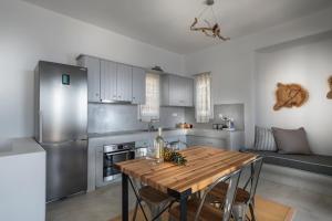 a kitchen with a wooden table and stainless steel appliances at Simousi Villas in Kithnos