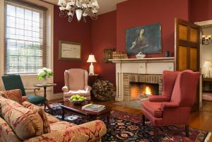 sala de estar con paredes rojas y chimenea en Inn and Cabins at Vaucluse Spring, en Stephens City