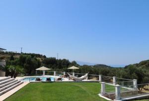 basen z hamakiem i trawnikiem w obiekcie Provarma hills luxury villa gerani w mieście Gerani